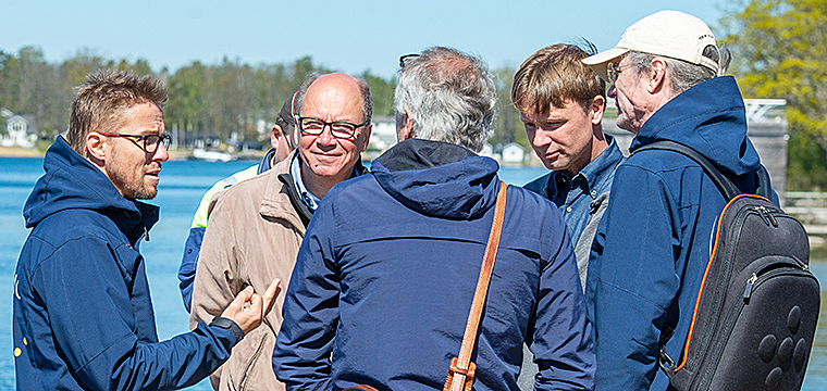 Group picture of people discussing outdoors.